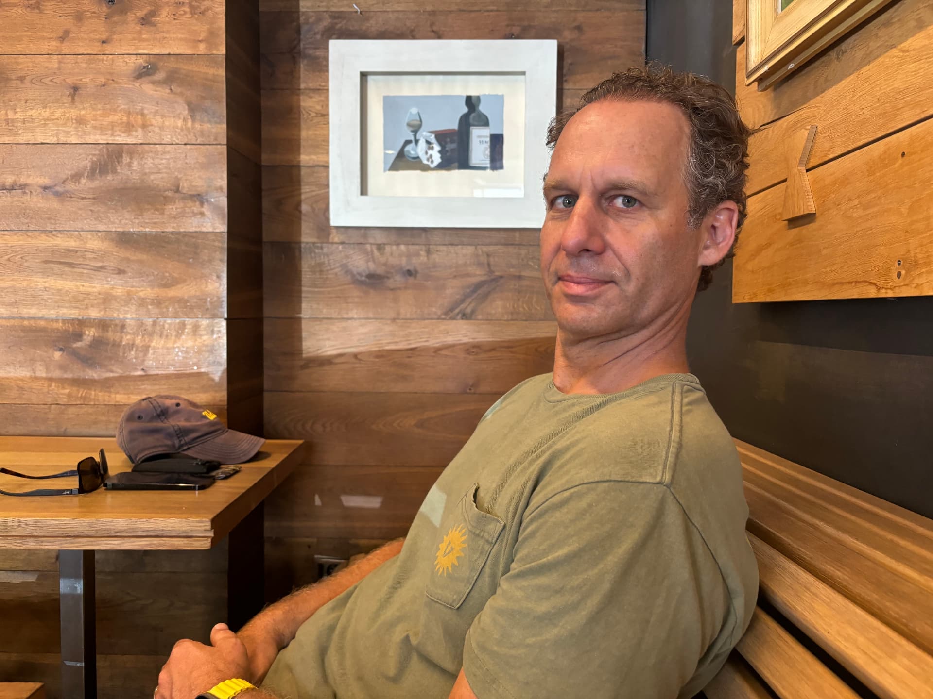Jonathan Raymond sitting in a wooden booth, looking at the camera